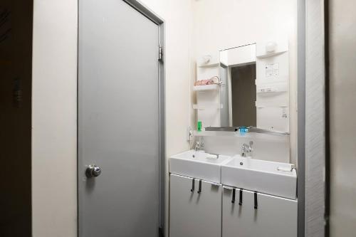 a bathroom with two sinks and a mirror at Backstage Party Hostel & Bar in Osaka