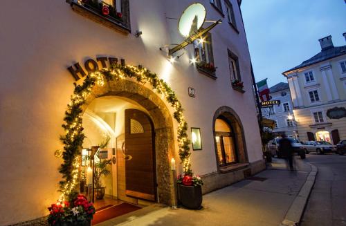 una entrada a un edificio con luces de Navidad en Hotel Wolf en Salzburgo