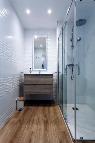 a bathroom with a sink and a glass shower at Cinco balcones a la Catedral by Unique Rooms in Burgos