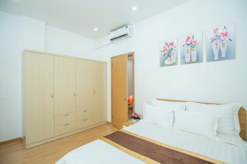 um quarto com uma cama branca e um armário em Sumitomo11 Apartment 5-39 Linh Lang em Hanói