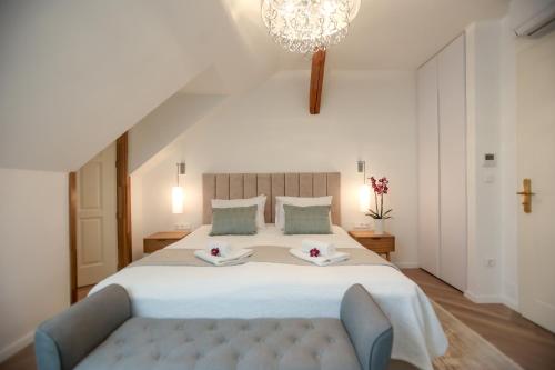 a bedroom with a large white bed and a chandelier at Vadkert Major in Sárvár