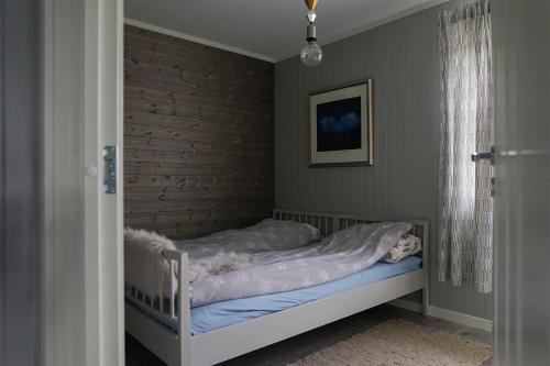 Cama pequeña en habitación con pared de ladrillo en Luxury Norwegian Cottage en Hurdal