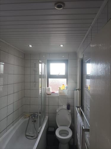 łazienka z toaletą, wanną i oknem w obiekcie 6 Bedroom House by the Sea w mieście Gemlik