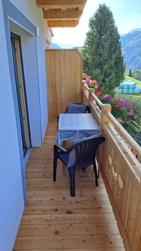 un balcón con mesa y sillas. en Ferienwohnung Egger, en Prägraten am Großvenediger