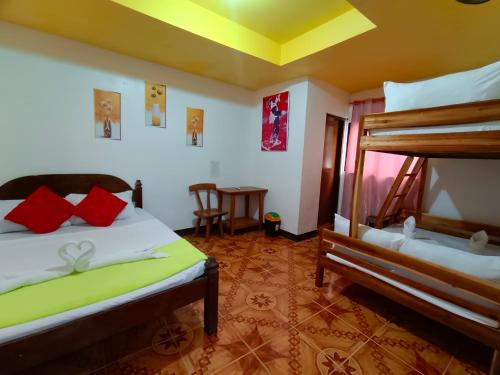 a bedroom with two bunk beds and a table at Yuki Lodge - El Nido PH in El Nido