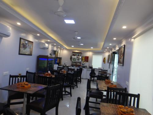 a dining room with tables and chairs in a restaurant at Angel Residency in Greater Noida