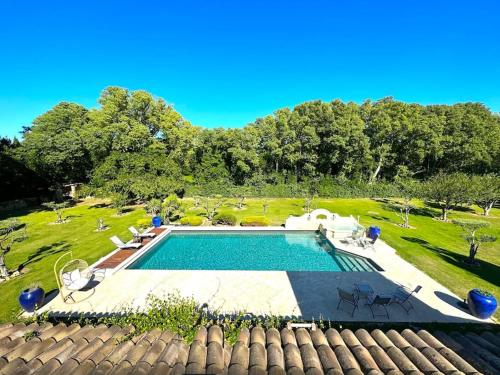 vistas a una piscina en un patio en Belle villa provençale dans un parc paysagé avec piscine et sauna, en Grans