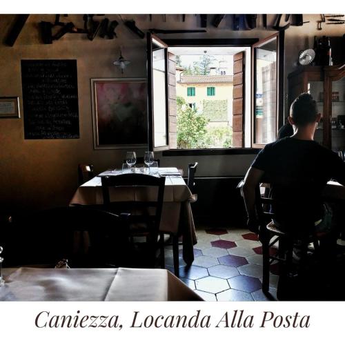 a man sitting at a table in a restaurant looking out the window at Locanda Alla Posta in Cavaso del Tomba