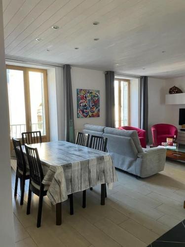 un salon avec une table, des chaises et un canapé dans l'établissement Maison Cantal à Marchastel 15400, à Marchastel
