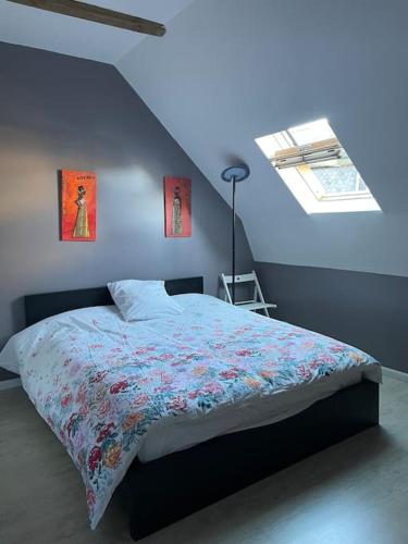 Cet appartement comprend une chambre dotée d'un lit avec un mur bleu et une fenêtre. dans l'établissement Maison Cantal à Marchastel 15400, à Marchastel