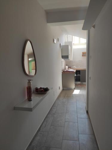 a white room with a mirror and a tile floor at Casa Leosini in LʼAquila