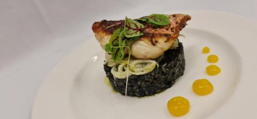 a white plate with a piece of food on top of black food at Crowne Plaza Marlow by IHG in Marlow