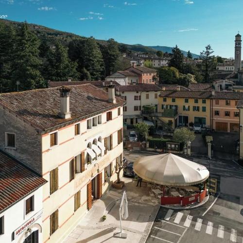 a building with a large umbrella in a city at Locanda Alla Posta in Cavaso del Tomba