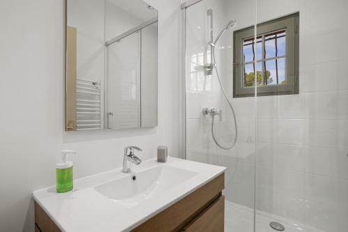 a white bathroom with a sink and a shower at Grande Villa entre Cannes St Tropez in Puget-sur Argens