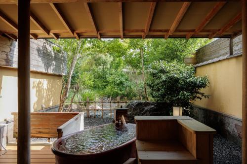 a patio with a bathtub and a table and bench at Kifuno Sato in Mimasaka