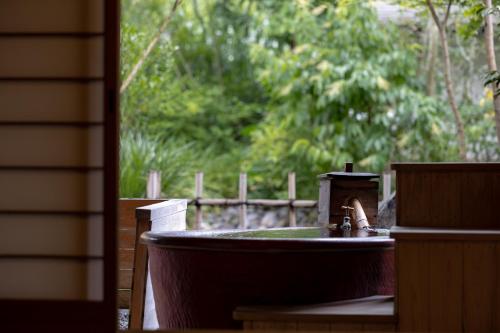 a bathtub with a faucet in a yard at Kifuno Sato in Mimasaka