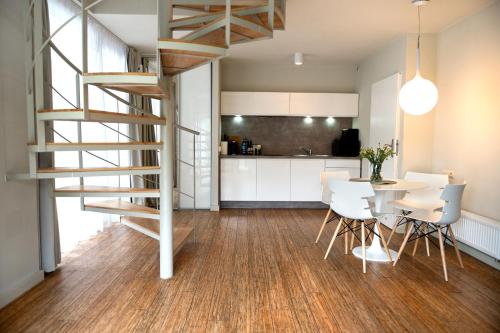 a kitchen and dining room with a spiral staircase in a house at Leśny Czar in Pogorzelica