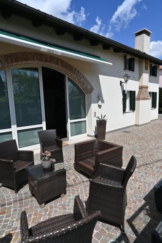 een patio met rieten stoelen en een tafel bij CA CENTOSA ARTISTIC HOUSE villa storica ristrutturata con patio e giardino in Cittadella