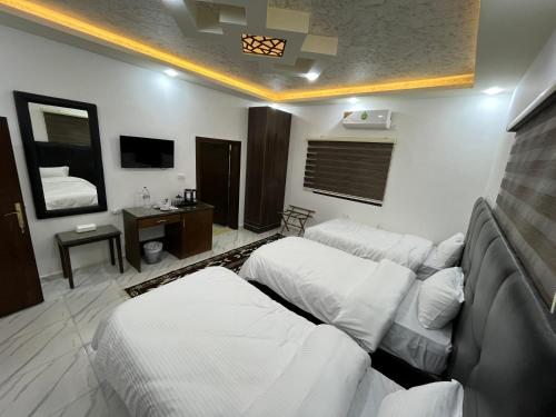 a hotel room with two beds and a television at Mansi Residence in Wadi Musa