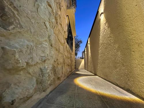 an alley way with a stone wall and a building at Mansi Residence in Wadi Musa