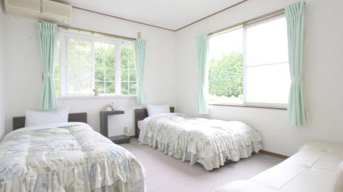 a bedroom with two beds and a window at Bellbird in Aso