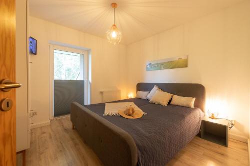 a bedroom with a bed with a hat on it at LM3-32 - Ferienwohnung Typ AB Komfort in Schottwarden