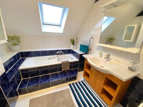 ein Badezimmer mit einer Badewanne, einem Waschbecken und einem Spiegel in der Unterkunft Teresa Guest House in Csömör