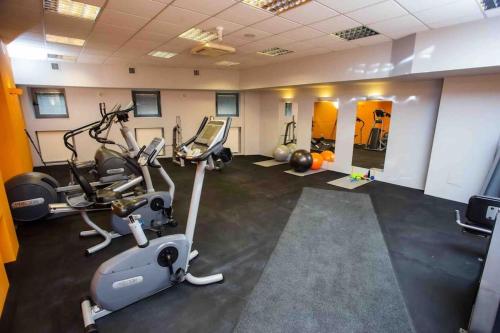 a gym with treadmills and elliptical machines at Mirror Apartment in Serock