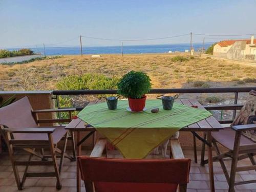 a table with a potted plant on a balcony at To spiti tis Xaras in Agia Anna