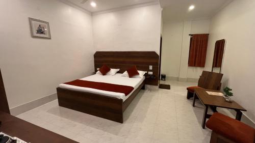 a bedroom with a bed and a table and a chair at Hotel Saluja in Siliguri