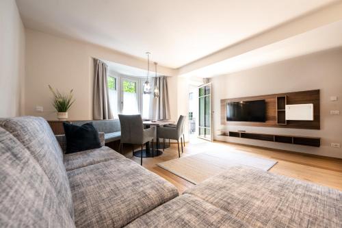 uma sala de estar com um sofá e uma sala de jantar em Odilia - Historic City Apartments - center of Brixen, WLAN and Brixencard included em Bressanone