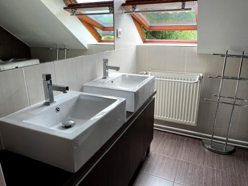 baño con lavabo blanco y ventana en Apartmán Štěpán, en Velké Karlovice