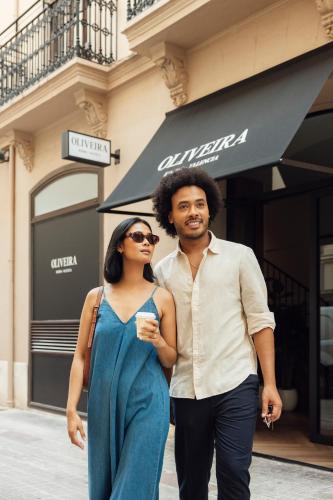 a man and a woman walking down a street at Room Mate Oliveira - City Centre, Valencia in Valencia