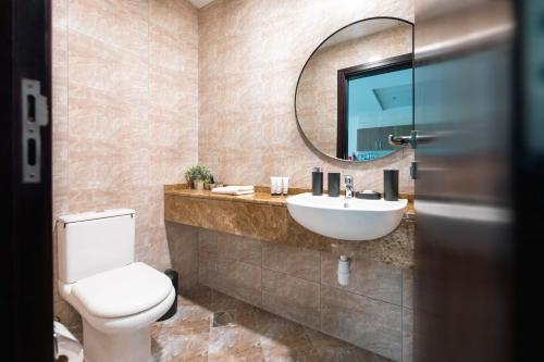 a bathroom with a toilet and a sink and a mirror at Charming Condo With Balcony In The Heart of JLT in Dubai
