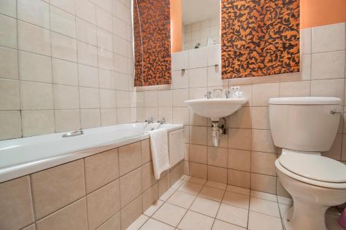 a bathroom with a toilet and a sink at Emakhosini Hotel On East in Durban
