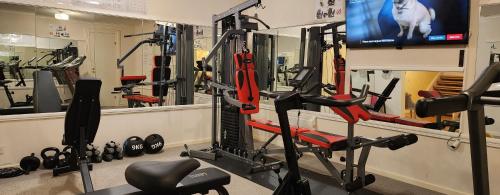 a gym with several tread machines and a tv at Vänerport Lakefront Hotell in Mariestad