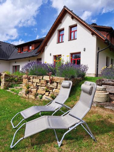 two lawn chairs sitting in front of a house at Ateliér 673 in Dolní Bečva