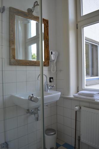 een badkamer met een wastafel en een spiegel bij Burger Fährhaus in Burgerfeld