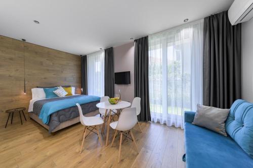- une chambre avec un lit, une table et des chaises dans l'établissement Elegance DeLuxe Studio, à Varna