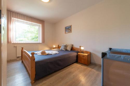 a bedroom with a bed and a window at LM5-17 - Ferienwohnung Typ AB Komfort in Schottwarden