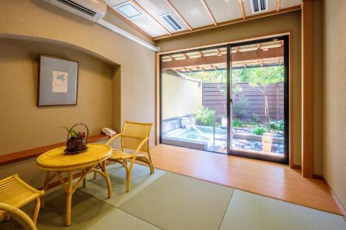 a room with a table and chairs and a window at Kifuno Sato in Mimasaka