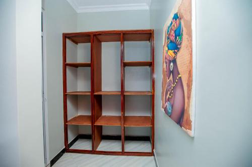 a shelf in a room with a painting on the wall at Niwa Apartments in Dar es Salaam