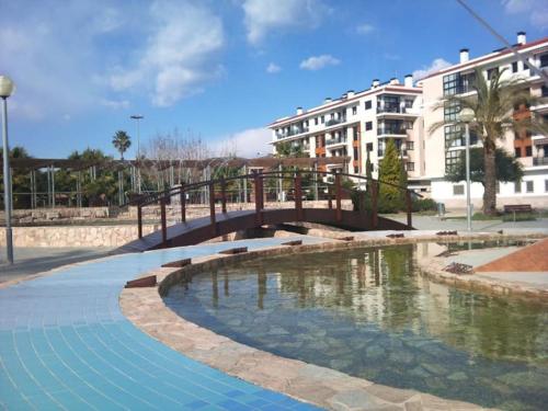 a bridge over a pool of water with buildings at Luxury Apartamenty in Pineda de Mar