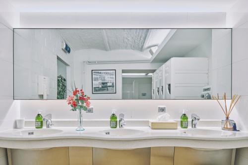 uma casa de banho branca com um lavatório e um espelho em The Legacy by 2GO4 City Center em Bruxelas