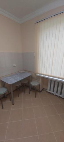 バルハシにある2-х комнатная квартираのテーブルと椅子、窓が備わる客室です。