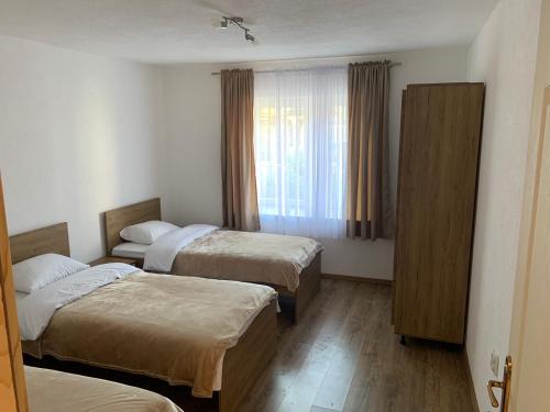 Cette chambre comprend 2 lits et une fenêtre. dans l'établissement Lejla's guesthouse, à Gusinje