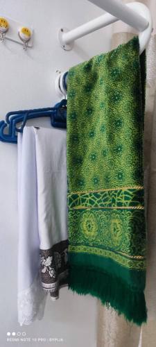 uma toalha verde está pendurada num suporte em FIZWAN HOMESTAY em Kuantan