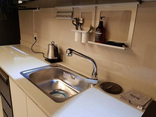 - un évier de cuisine avec un robinet sur un comptoir dans l'établissement Ash Mellow, à Daegu