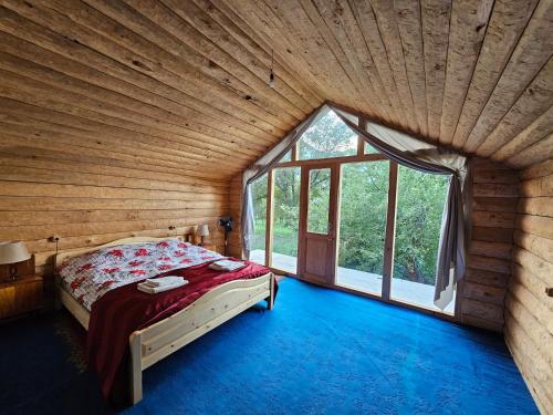 a bedroom with a bed and a large window at Guest House Aleksandre in T'mogvi