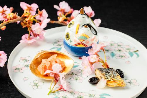 a plate of food with flowers and a toy on it at Kifuno Sato in Mimasaka